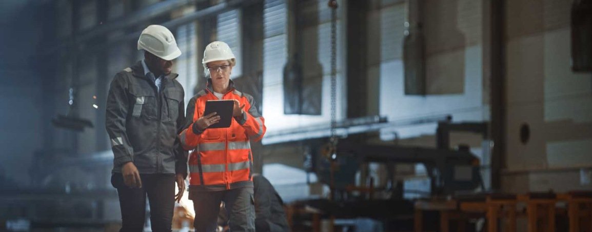 Two automotive workers reading a clipboard