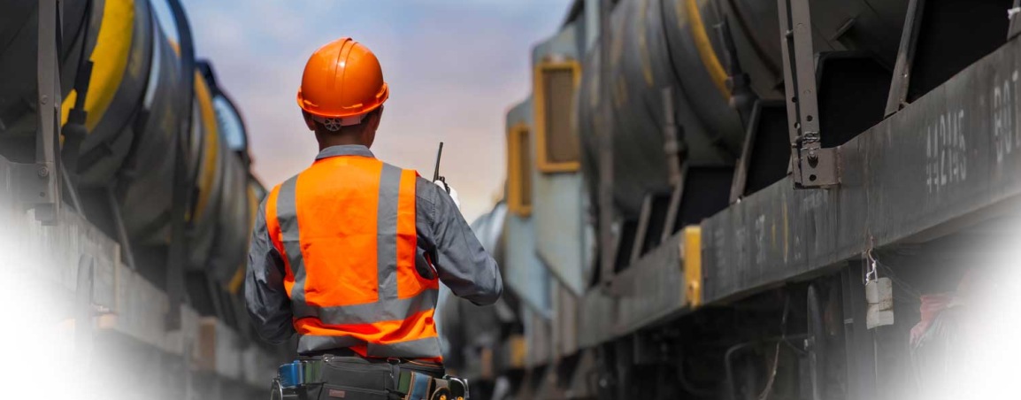 Rail worker stood between two train cars